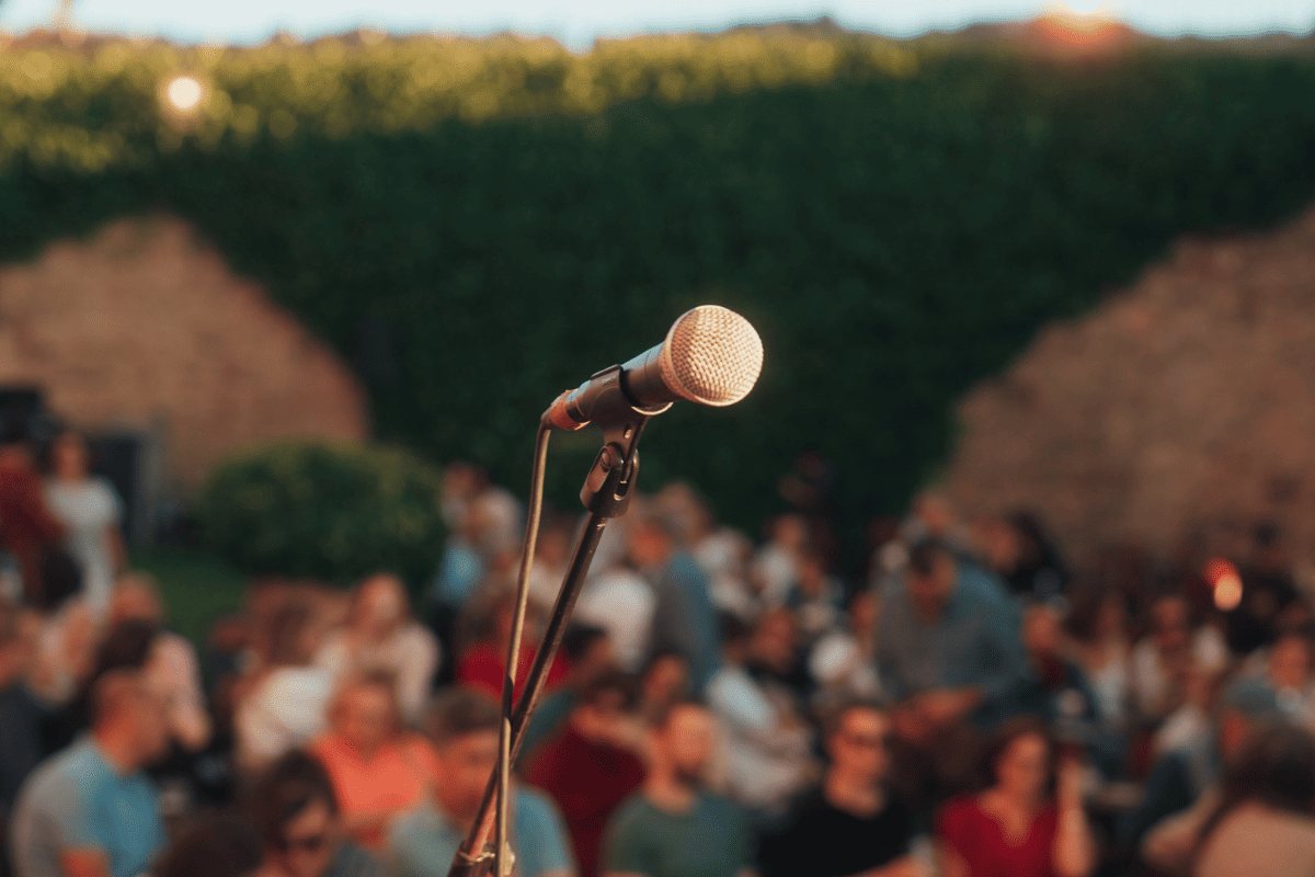 Micrófono frente a público en concierto al aire libre