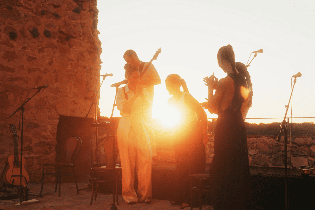 Músicos actuando al atardecer en escenario al aire libre