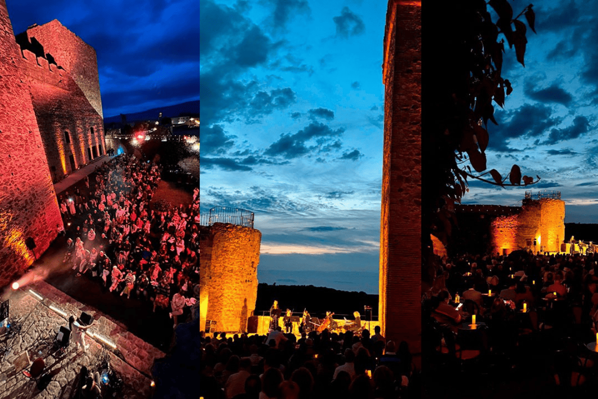 Concierto nocturno en el castillo con público y escenario iluminado